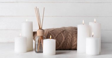 Mumları kamış ayırıcı ile yakmak ve beyaz masada örgü örmek.