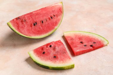 Bej arka planda olgun karpuz parçaları olan kompozisyon, yakın plan.