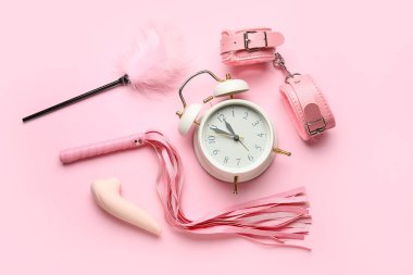 Pembe arka planda seks oyuncakları olan çalar saat