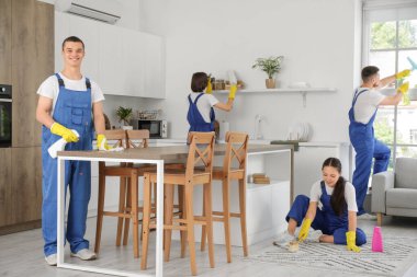 Genç hademeler mutfağı temizliyor.