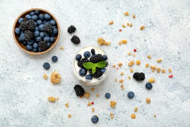 Hafif arkaplanda yoğurt bulunan bir bardak lezzetli granola.