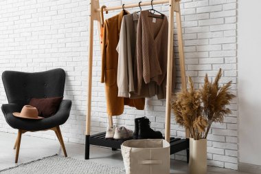 Modern koridorun içinde kalın giysiler ve koltuklar var.