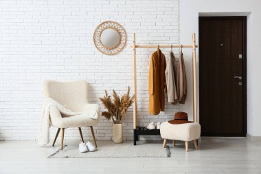 Modern koridorun içinde kalın giysiler ve koltuklar var.