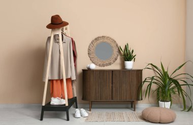 Sonbahar kıyafetleri, çekmeceler ve modern koridorun iç tarafındaki aynalarla dolu.