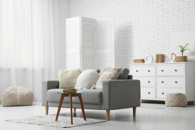 Oturma odasındaki kanepenin yanındaki masada eski bir kitap.