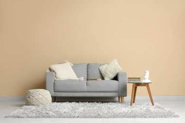 Odadaki bej duvarın yanındaki cam masanın üzerinde bir yığın eski kitap var.