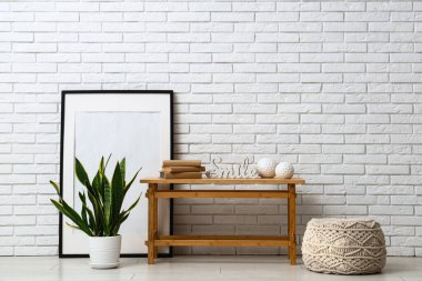 Odanın içinde beyaz tuğla duvarın yanında eski kitaplarla dolu bir banka.