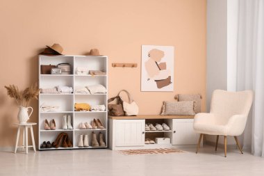 Katlanmış giysiler, ayakkabılar ve aksesuarlarla dolu bir soyunma odası.