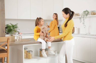 Genç lezbiyen çift ve küçük kızları mutfakta.