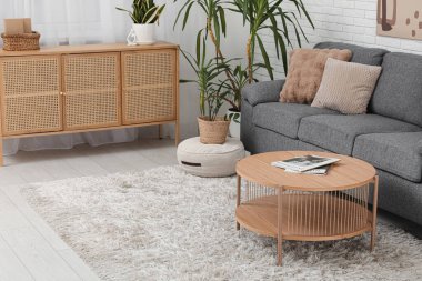 Rahat kanepesi, sehpası ve çiçekli modern bir oda.