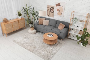 Rahat gri bir kanepe ve şık bir odanın içindeki kahve masası.