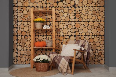 Rahat koltuklu, kasımpatı çiçekli ve balkabaklı şık bir oturma odası.