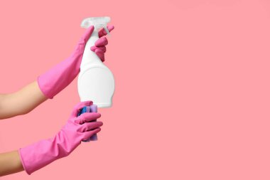 Küf çıkarıcı ve pembe arka planda sünger olan kadın elleri