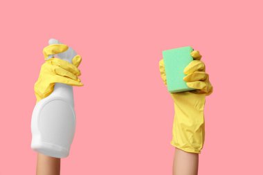 Küf çıkarıcı ve pembe arka planda sünger olan kadın elleri