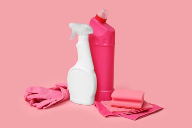 Pembe arka planda küf çıkarıcı, sünger ve eldiven şişeleri