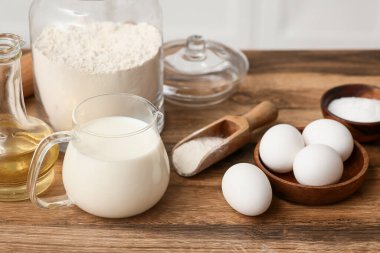 Kavanozda un, yumurta kepçesi, süt ve yağ mutfak tezgahında hamur hazırlamak için.