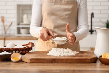 Mutfak tezgahında hamur hazırlayan kadın.