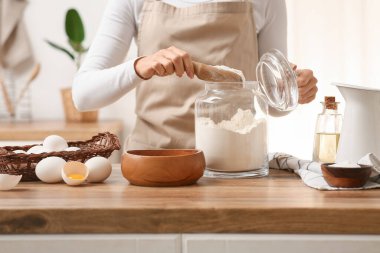 Kadın mutfak tezgahında hamur hazırlıyor.