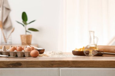 Mutfak tezgahında hamur hazırlamak için yumurta, tereyağı ve çırpılmış un yığını.