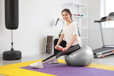 Spor salonunda spor salonunda spor yapan vücut silindirli genç bir kadın.