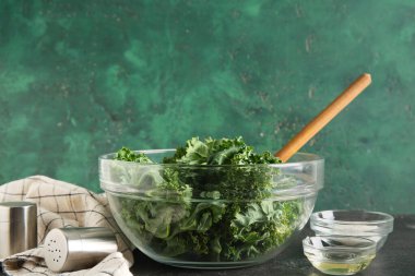 Siyah masada taze lahana yapraklı cam kase.