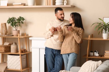 Evlerinde şöminenin yanında çay içen mutlu çifti severler.