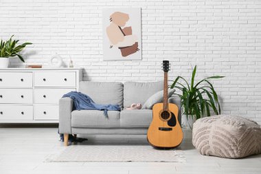 Modern akustik gitar şık bir oturma odasında yerde.