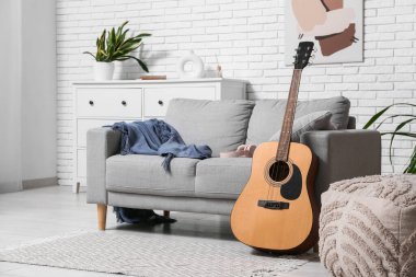 Modern akustik gitar şık bir oturma odasında yerde.