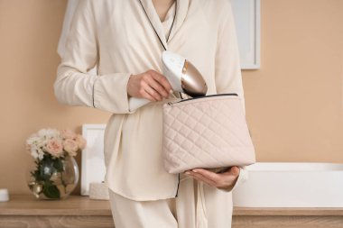 Modern fotokopi makinesi ve kozmetik çantasıyla banyoda güzel bir genç kadın.