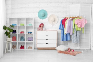 Askısı, çekmecesi ve raf ünitesi olan şık bir soyunma odası.