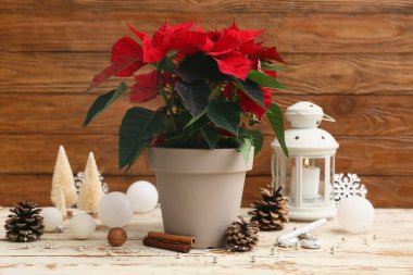 Fenerli kompozisyon, güzel Noel süslemeleri ve açık ahşap masa üzerindeki noktalama seti.