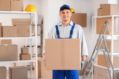 Depoda karton kutusu olan bir erkek yükleyici.