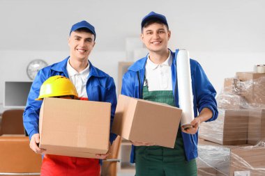 Bükük ambalajlı ve kutulu erkek yükleyiciler ofiste.