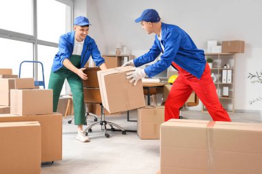 Erkek yükleyiciler ofiste kutuları boşaltıyorlar