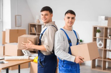 Ofisinde karton kutular olan erkek yükleyiciler.