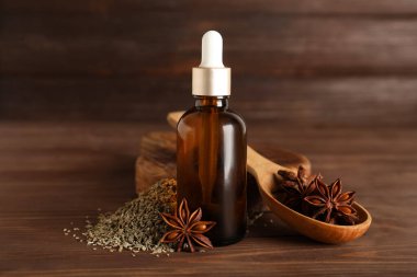 Ahşap arka planda gerekli yağ, kurutulmuş tohumlar, kaşık ve anason yıldızlarıyla dolu bir tahta.