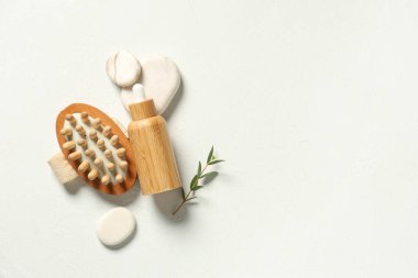 Gerekli yağ şişesi, masaj fırçası ve renk arkaplan üzerine spa taşları