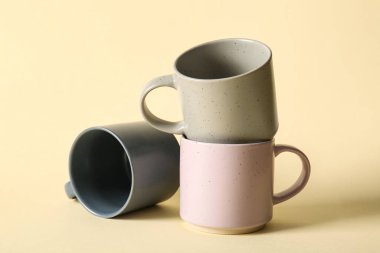 Renk arkaplanında farklı seramik bardaklar