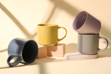 Renkli arkaplanda farklı seramik bardaklar kümesi