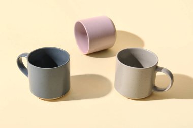 Renk arkaplanında farklı seramik bardaklar