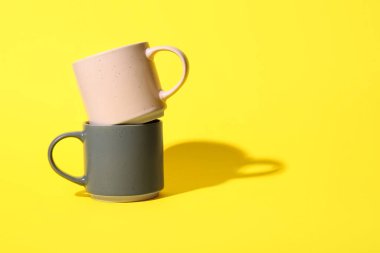 Sarı arkaplanda seramik bardaklar