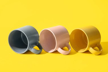 Sarı arkaplanda farklı seramik bardaklar