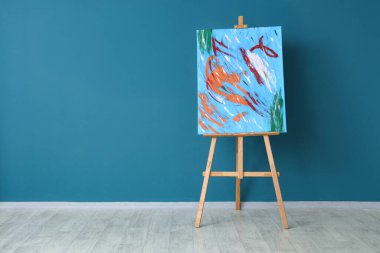 Mavi duvarın yanındaki sehpada boyama