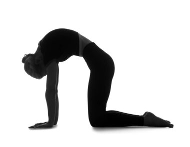 Beyaz arka planda yoga yapan genç bir kadının silueti.