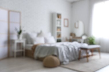 Yatak odasının içinde tuvalet masası, raf ünitesi ve beyaz tuğla duvarın yanında yatak, bulanık görüş.