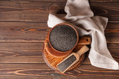 Ahşap zemin üzerinde chia tohumları ile kase ve kepçe