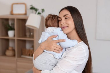 Genç anne evde bebeğine sarılıyor. Uluslararası Sarılma Günü