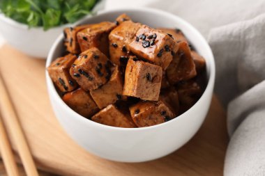 Beyaz arka planda kızarmış tofu peyniri parçaları olan kase, yakın plan.