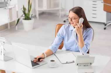 Ofiste telefonla konuşan güzel bir sekreter.