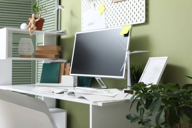 Ofisinde boş bilgisayar monitörü ve rüzgar türbini modelleri olan mühendis işyeri